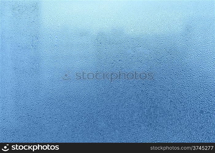 Blue background with natural water drops on glass