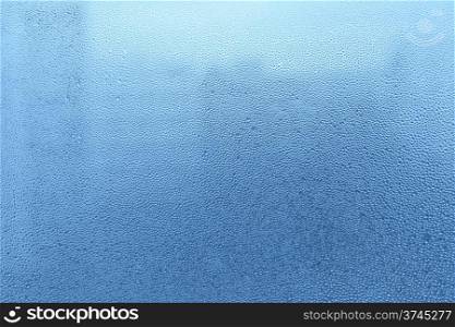 Blue background with natural water drops on glass