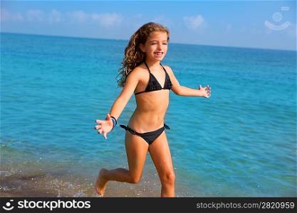 blue beach kid girl with bikini jumping and running splashing water