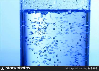 blue bubbled water in glass