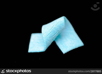 blue chewing gum wrapped in spiral on the black background