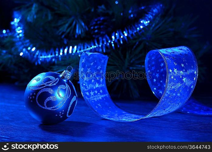 Blue Christmas collage. Ball and ribbon on a blue background.