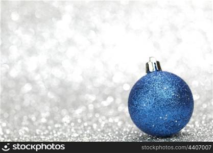 Blue christmas decoration ball on silver shiny background