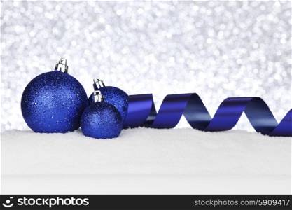 Blue Christmas decorations on snow close-up. Christmas decorations on snow