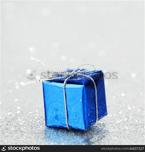 Blue Christmas gift box on shiny silver background