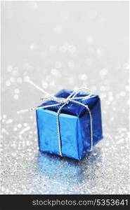Blue Christmas gift box on shiny silver background