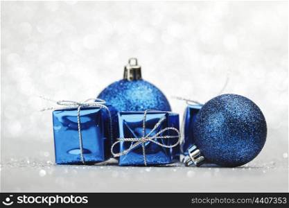 Blue Christmas gift boxes and balls on shiny silver background