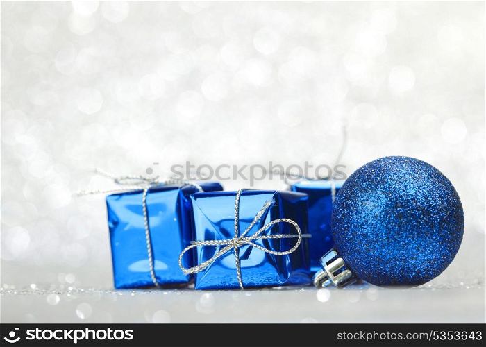 Blue Christmas gift boxes and balls on shiny silver background