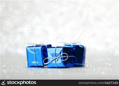 Blue Christmas gift boxes on shiny silver background