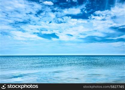 Blue clear sea and sky with white clouds
