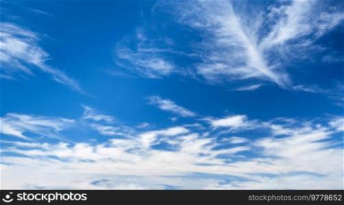 Blue clear sky with white cirrus spindrift clouds background. Blue clear sky with clouds