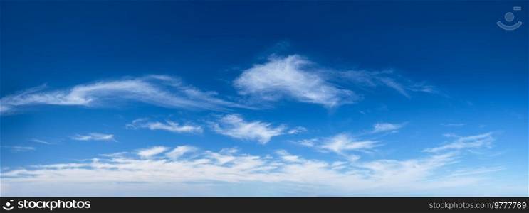 Blue clear sky with white cirrus spindrift clouds background panorama. Blue clear sky with clouds