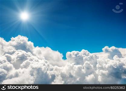 Blue clouds and sky and shining sun. Natural cloudscape background