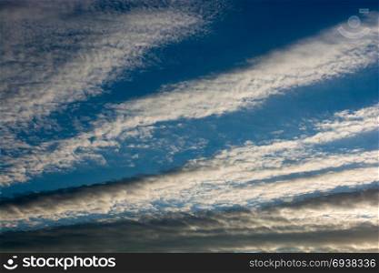 Blue cloudy sky with white and grey clouds