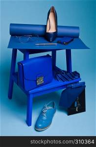 Blue color fashion style still life setup on blue background with shoe tie glasses bag pen and notebook