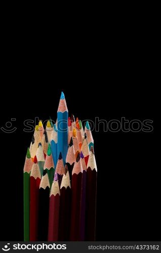 blue color pencil stands out among many color pencils on black background , selective focus.. blue color pencil stands out among many color pencils on black background , selective focus
