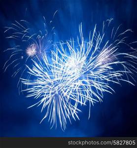 Blue colorful fireworks in heart shape on the black sky background. Holiday celebration.
