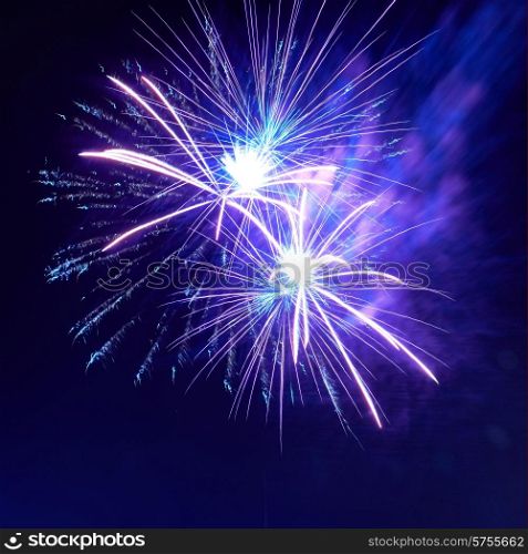 Blue colorful fireworks on the night black sky background. Holiday celebration.