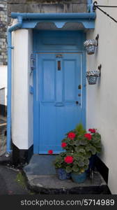 Blue cottage door with geraniums, Polperro, Cornwall, England.