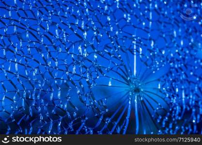 Blue cracked glass pane cloes-up creating interesting cell-like abstract patterns. Conceptual image