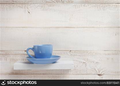 blue cup on white wooden plank background