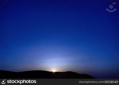Blue dark night sky with many stars. Moon rising. Space background. Blue dark night sky with stars