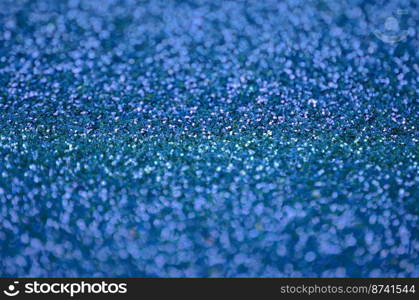 Blue decorative sequins. Background image with shiny bokeh lights from small elements that reflect light. Blue decorative sequins. Background image with shiny bokeh lights from small elements