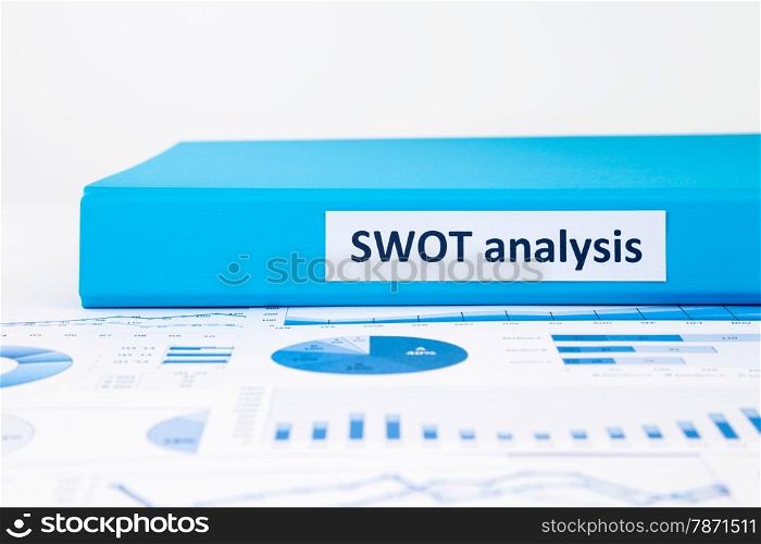 Blue document binder of SWOT analysis place on business graph report concept to evaluate and planning projects