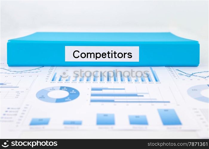 Blue document binder with competitors word place on graph analysis, concept for business strategic planning
