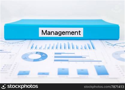 Blue document binder with management word place on graph analysis of evaluation report concept for business strategic planning