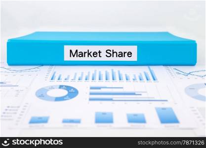 Blue document binder with Market Share word place on graph analysis, charts and Marketing reports