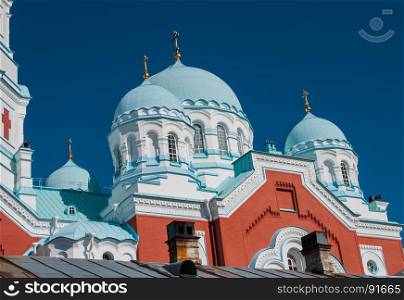 Blue domes of a Christian temple against a blue sky on a summer day