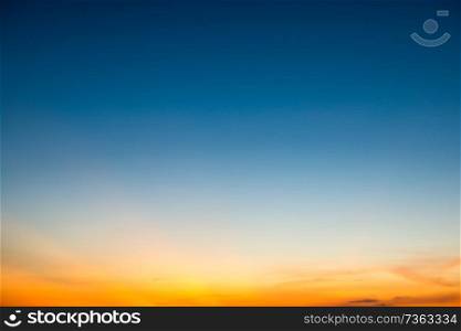 Blue dramatic sunset sky with golden rays of sun light. Can be used as nature background