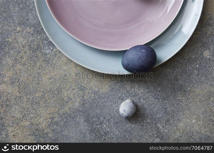 Blue easter eggs with plates on stone background. Painted easter eggs