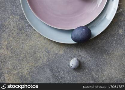 Blue easter eggs with plates on stone background. Painted easter eggs