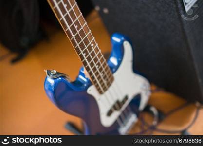 Blue electric bass guitar on the floor for recording