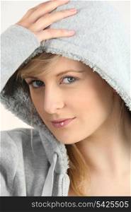 blue-eyed blonde wearing with hand on hood