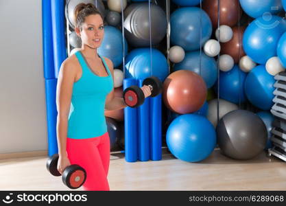 Blue eyes girl at gym weightlifting dumbbells in fitness training