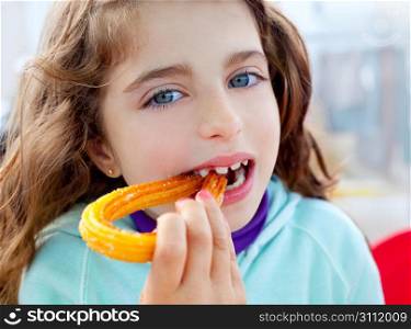 Blue eyes little girl eating churros fried crullers smiling