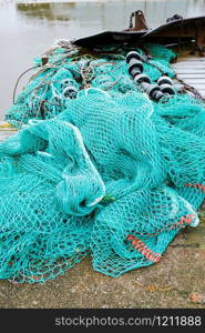 blue fishing net on a pontoon with its ropes and floats covered with morning frost