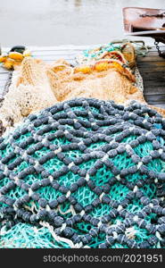 blue fishing net on a pontoon with its ropes and floats covered with morning frost