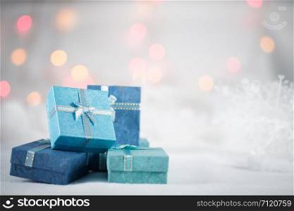 Blue gift boxes on the white fur on bokeh background, with copy space for season greeting. Merry Christmas or Happy New Year.AF point selection,blurred