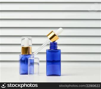 blue glass bottle with a pipette on a white background. Template for cosmetic liquid products, advertising and promotion