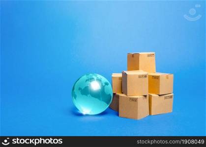 Blue glass globe and cardboard boxes. International world trade distribution. Delivery of goods, shipping. Global economy, import export freight traffic. Globalization markets. Economics development.