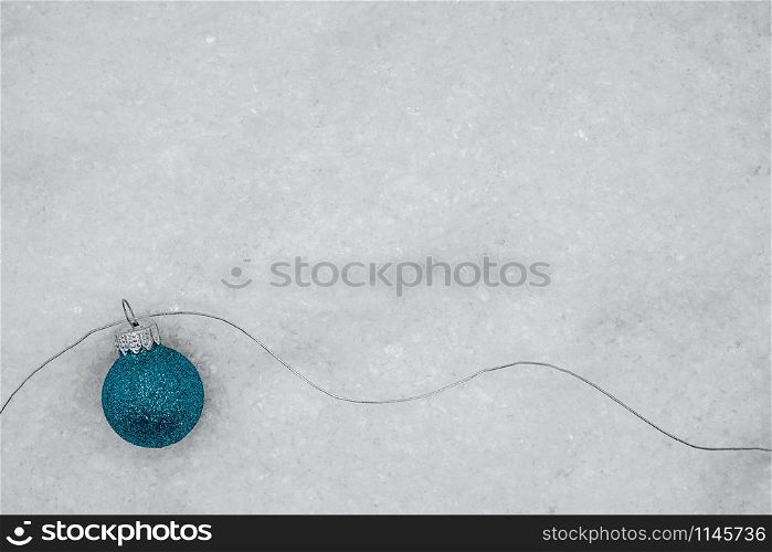 blue glittering Christmas ball with silver thread on snow