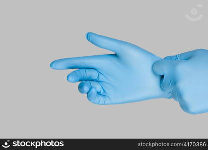 Blue gloves on a hand on a grey background