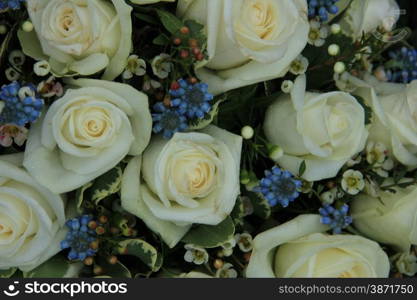 Blue grape hyacinths and white roses in a wedding flower arrangement