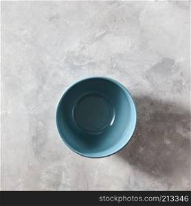 Blue hand crafted chinese bowl blue color on gray stone background with copy space. Flat lay. Blue porcelain bowl isolated on stone gray background, flat lay