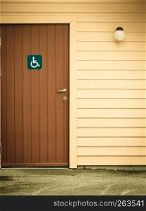 Blue handicapped wheelchair sign on door of public toilet outdoor, WC restroom. Blue handicapped wheelchair sign on door of public toilet