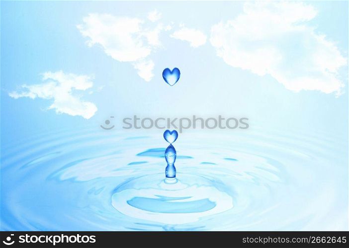 Blue heart shaped water droplets falling into blue water